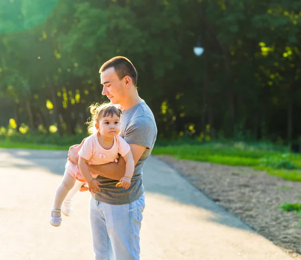 Bébé fille marche dans un parc d'été avec son père — Photo