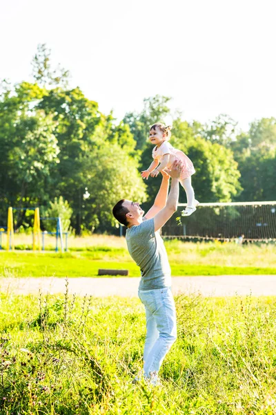 Baby girl walking in a summer park with her father — Stock Photo, Image