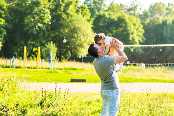 Bébé fille marche dans un parc d'été avec son père — Photo