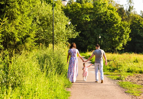 Glad ung familj promenader i parken. — Stockfoto