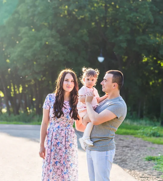 公園を歩く幸せな若い家族. — ストック写真