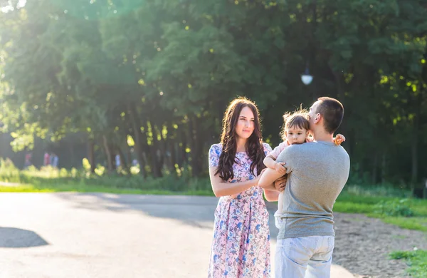 Joyeux jeune famille marchant dans le parc. — Photo