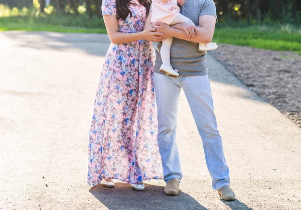 Glückliche junge Familie spaziert durch den Park. — Stockfoto