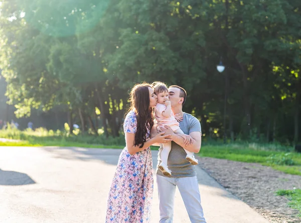 Felice giovane famiglia passeggiando nel parco. — Foto Stock