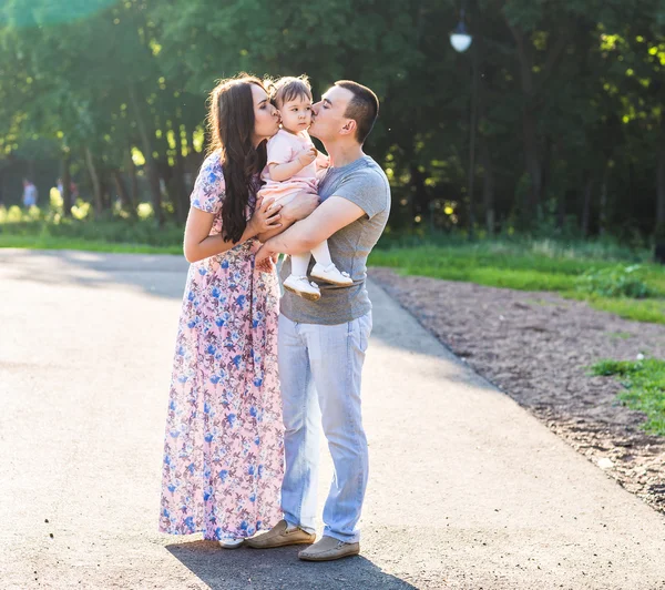 Glad ung familj promenader i parken. — Stockfoto