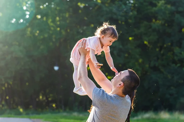 Joyeux jeune famille marchant dans le parc. — Photo