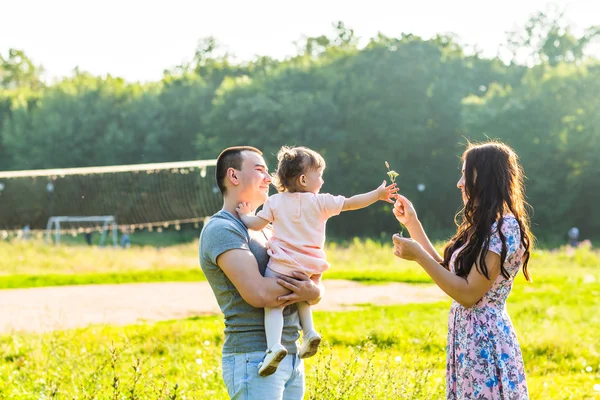 Feliz familia joven caminando en el parque. — Foto de Stock