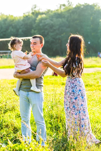 Feliz familia joven caminando en el parque. — Foto de Stock