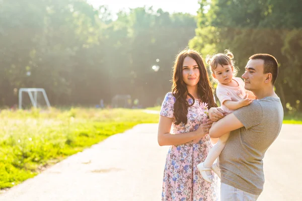 Felice giovane famiglia passeggiando nel parco. — Foto Stock