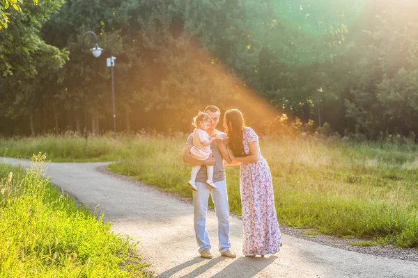 Jovem família feliz andando no parque. — Fotografia de Stock