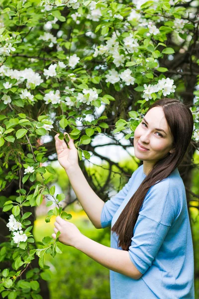 Портрет весенней брюнетки, стоящей под открытым небом на цветущих деревьях . — стоковое фото