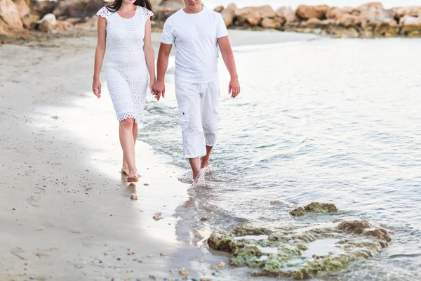 Casal caminhando juntos ao longo da praia — Fotografia de Stock
