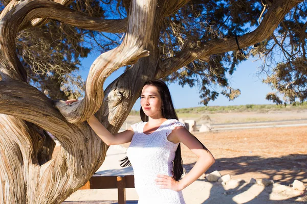 Schöne Frau steht am Baum — Stockfoto