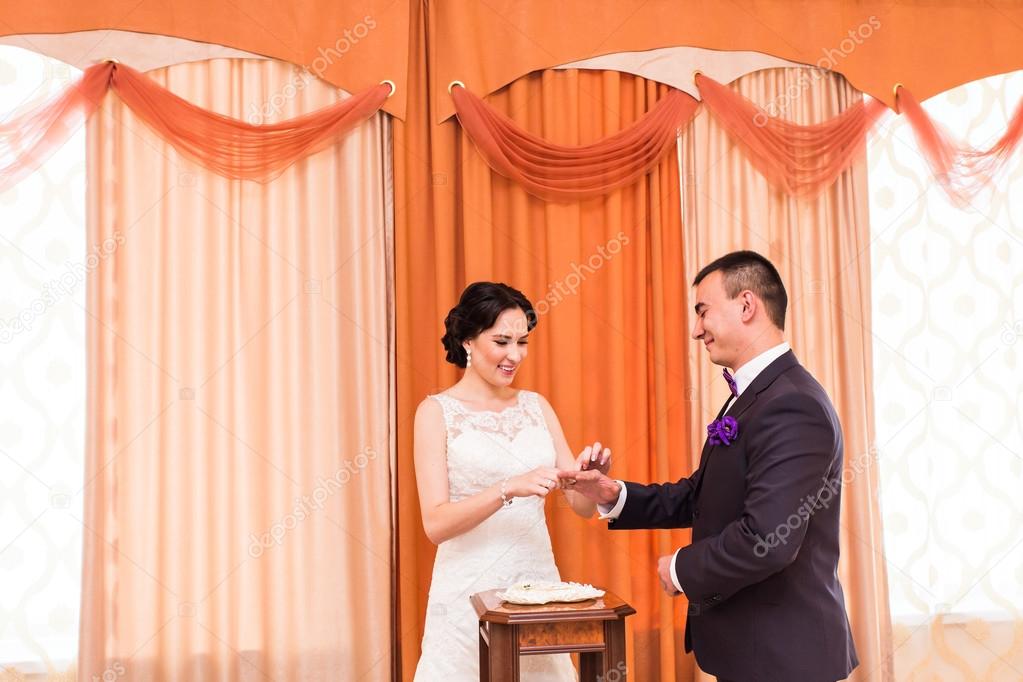 groom putting ring on brides finger