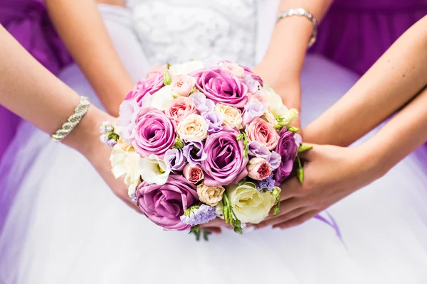 Close-up de uma noiva e suas damas de honra segurando buquê . — Fotografia de Stock