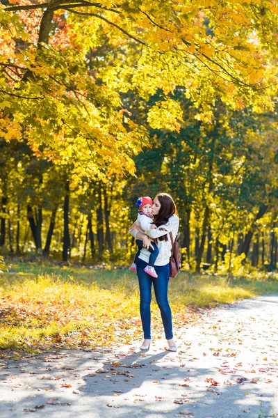 Mère de famille heureuse avec enfant petite fille courir et jouer sur le parc d'automne — Photo
