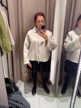 Deneme odasında krem rengi ceket deniyorum. Kişisel tarzın keşfi, vücut güveni ve modanın kendini ifade etme şekli gelişigüzel minimalizm ve nötr tonlar ile