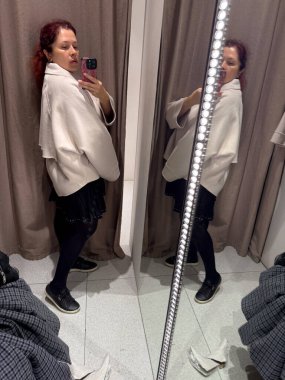 Bej ceketli bir kadının yan görüntüsü. Orantı algısı, siluet ve kadınsı güç rahat bir zarafet ve dikkatli bir benlik imajı ile.