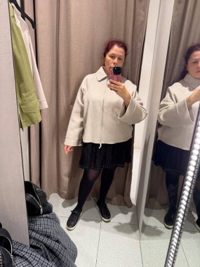 Bej ceketli ve bordo pantolonlu boy ayna portresi. Bireyselliğin ifadesi, vücut kabulü ve günlük şehir moda bağlamında dengeli siluet