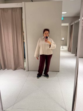 Ceket ve pantolonla renksiz kıyafet kombinasyonu. Kişisel kimlik, rahatlık ve minimalist moda ortamında güven üzerine sakin bir yansıma.