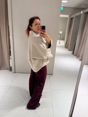 Koyu renk pantolonlu, bej ceketli yan profil. Kibar hareketin, orantı dengesinin ve sonbahar modasında duygusal yumuşaklığın temsili