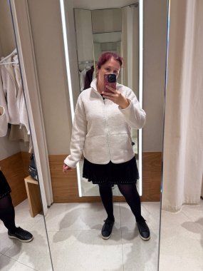 Deneme odasında krem rengi ceket deniyorum. Kişisel tarzın keşfi, vücut güveni ve modanın kendini ifade etme şekli gelişigüzel minimalizm ve nötr tonlar ile