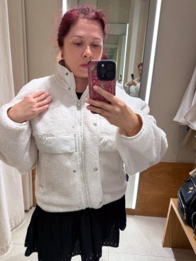 Deneme odasında krem rengi ceket deniyorum. Kişisel tarzın keşfi, vücut güveni ve modanın kendini ifade etme şekli gelişigüzel minimalizm ve nötr tonlar ile