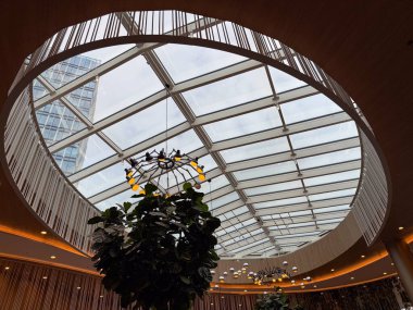 Şehir mimarisinde modern cam tavan yapısı. Şeffaflık, geometri ve doğal ışık üzerine yansıma açıklık, yenilik ve mekansal uyumun sembolleri olarak.