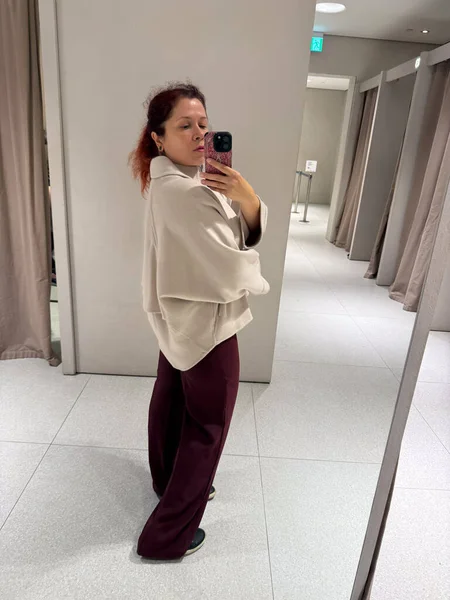 Koyu renk pantolonlu, bej ceketli yan profil. Kibar hareketin, orantı dengesinin ve sonbahar modasında duygusal yumuşaklığın temsili