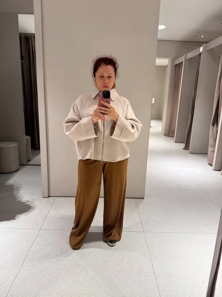 Açık renk ceketli ve kahverengi pantolonlu bir kadın. Uyum, doku ve denge üzerine modern yansıma bilinçli çağdaş yaşam tarzı ve moda estetiği