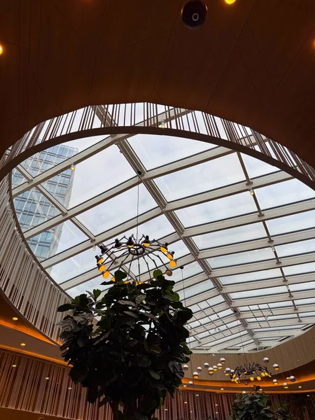 Şehir mimarisinde modern cam tavan yapısı. Şeffaflık, geometri ve doğal ışık üzerine yansıma açıklık, yenilik ve mekansal uyumun sembolleri olarak.