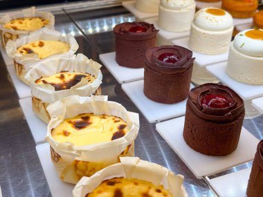 Sırayla dizilmiş çikolatalı ve peynirli tatlı çeşitleri. Pasta çeşitliliği ve şekerleme sanatını ifade eden formların çeşitliliği