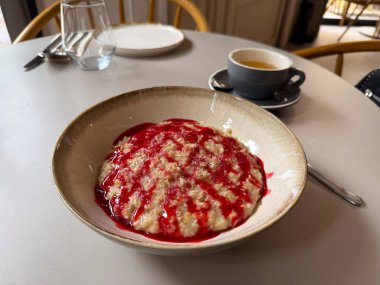 Kasede servis edilen ahududu soslu yulaf ezmesi. Kahvaltı, beslenme ve rahat bir sabah hayatı.