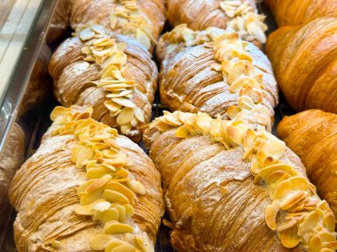 Fırın rafında bademli kruvasan. Tatlı pasta, Fransız geleneği ve hoşgörülü kahvaltı deneyimi.