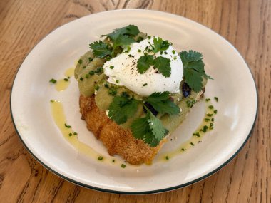 Avokado tostu, haşlanmış yumurta ve tabakta otlar. Sağlıklı kahvaltı, modern mutfak ve doğal malzemeler ve minimum tasarım içeren taze mutfak estetiği.