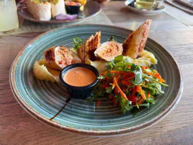 Restoranda servis edilen patates püresi ve salatalı tavuk filetosu. Tazelik, denge ve modern mutfağın görsel ahengi..