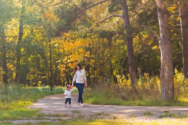 Genç anne ile bebeği bir sonbahar Park yürüme