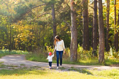 Genç anne ile bebeği bir sonbahar Park yürüme