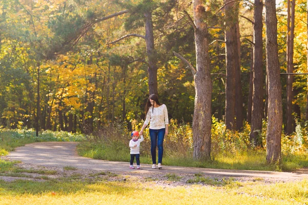 Genç anne ile bebeği bir sonbahar Park yürüme