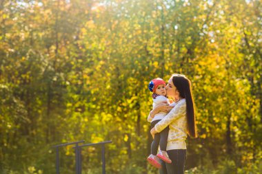 Genç anne ile bebeği bir sonbahar Park yürüme