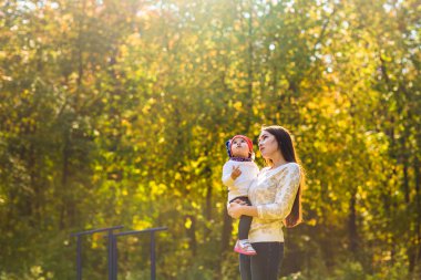 Genç anne ile bebeği bir sonbahar Park yürüme