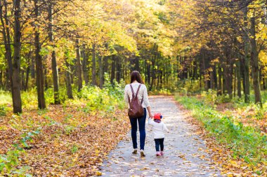 Genç anne ile bebeği bir sonbahar Park yürüme