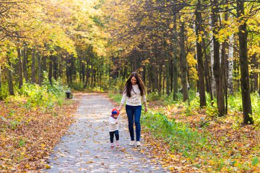 Genç anne ile bebeği bir sonbahar Park yürüme