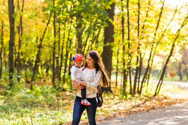 Jeune mère marchant avec son bébé dans un parc d'automne — Photo