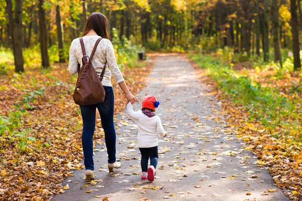 Genç anne ile bebeği bir sonbahar Park yürüme