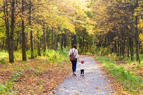 Молодая мама гуляет со своим ребенком в осеннем парке — стоковое фото