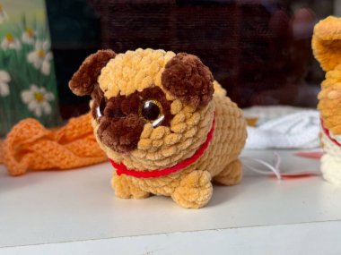 Pug dog 'a benzeyen pelüş bir oyuncak. Çocukluk nostaljisi, rahatlık ve el yapımı yaratıcılık yumuşak dokuya ve sıcak tonlara yansıyor.