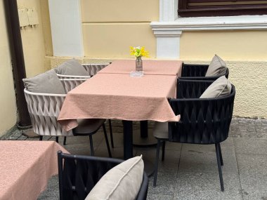 Açık kafe köşesinde pastel masa örtüleri ve çiçekler var. Avrupa sokak yemekleri atmosferinin sakinliği, konukseverliği ve cazibesi.