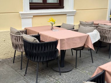 Açık kafe köşesinde pastel masa örtüleri ve çiçekler var. Avrupa sokak yemekleri atmosferinin sakinliği, konukseverliği ve cazibesi.