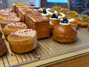Fırında taze hamur işleri ve kremalı çörekler ve yaban mersini sergileniyor. Modern Avrupa hamur işi eğilimleri.